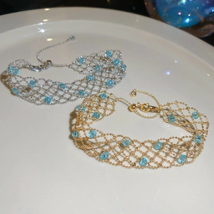 Detail showing woven mesh bracelets in gold and silver with blue crystal centerstones