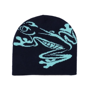 Detailed close-up of dark blue knitted frog beanie with precise embroidery on plain white