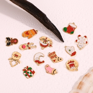 Detail of colorful enamel Christmas charms with gold plating on a natural background
