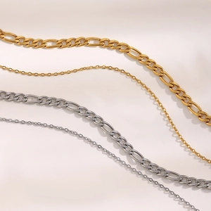 Detail of 18K gold and silver layered necklaces featuring Cuban and fine links