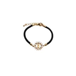 Religious woven bracelet with gold-toned charms and cubic zirconia on a white background
