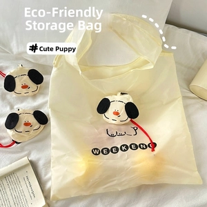 Detail of foldable yellow shopping bag with puppy pattern and compact storage pouch
