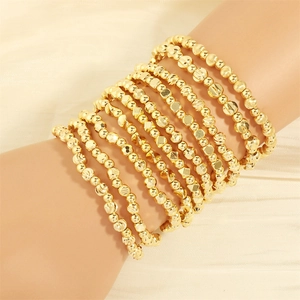 Set of 10 gold multi-layer beaded bracelets with irregular shapes and textured finishes