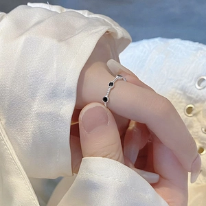Minimalist S925 sterling silver twisted ring with black enamel dots on a female hand