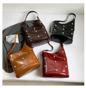 Flat lay of vintage bucket bags in brown, black, tan, and red with silver rivets
