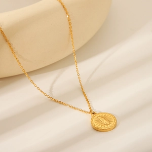 Close-up of 18K gold-plated stainless steel necklace with sunburst and angel relief pendant