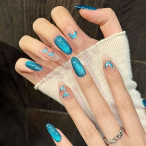 Blue cat eye press-on nails with butterfly charms and a silver镂空butterfly ring