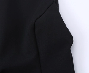 Close-up of fabric texture and stitching detail on a black sleeveless bow dress