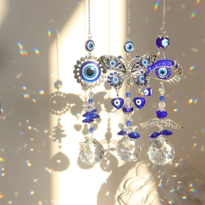 Detail of crystal suncatchers with blue evil eye charms creating rainbow light reflections
