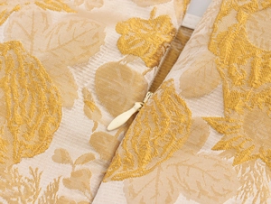 Makroaufnahme des unsichtbaren beigen Reißverschlusses auf floralem Jacquard-Stoff