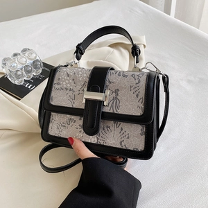 Close-up of the silver H-shaped metal buckle on a floral pattern handbag with leather strap