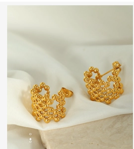Detailed close-up of 18K gold plated mesh sphere bead earrings on a white silk surface