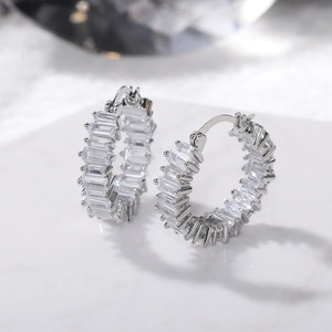Macro detail of silver hoop earrings featuring baguette-cut AAA cubic zirconia stones