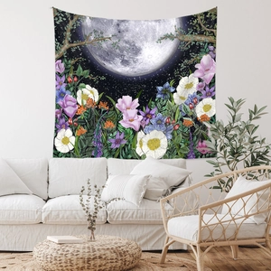 Detail of bohemian wall tapestry featuring moon phases and colorful floral art in a living room