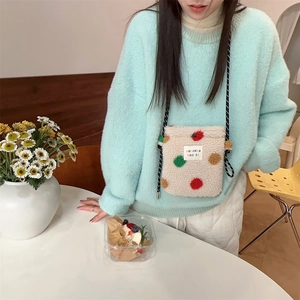Détail du sac bandoulière en peluche à pois arc-en-ciel avec sangle tressée