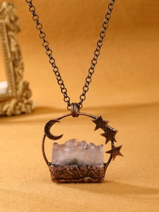 Macro shot of vintage amethyst moon and star pendant with antique copper finish texture