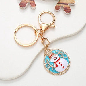 Detailed macro view of Christmas snowman keychain with gold metal and sparkling rhinestones