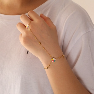 Golden flower hand chain bracelet with colorful enamel clover charms on model