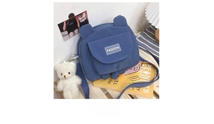 Detailed shot of a blue canvas bear bag with cute ears and plush bear charm