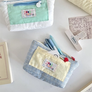 Close-up of cute canvas stationery bags in mint green and light blue with stylish labels