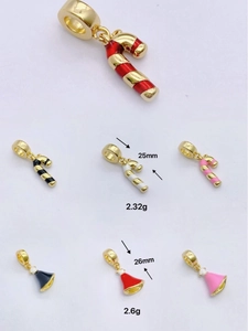 Detailed macro view of 18k gold-plated Christmas candy cane and bell enamel charms