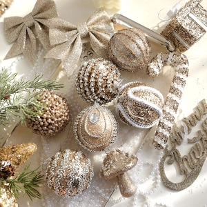 Champagne gold Christmas ornament set with glitter balls and bows on pine branches