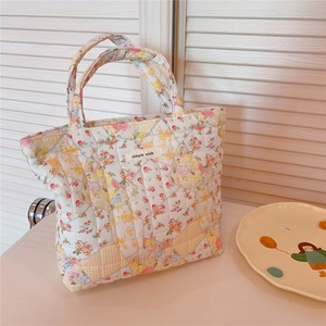 Detail of floral quilted handbag featuring diamond patterns and simple wish label