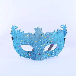 Detailed view of the bright blue glitter texture and intricate cutout lace pattern on mask
