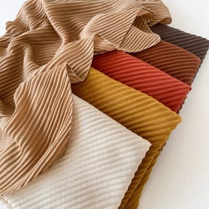 Detail shot of multi-color pleated fabric scarves showing soft texture and folded drape