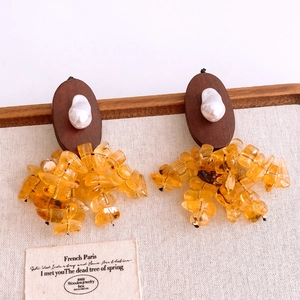Detailed view of vintage long drop earrings with amber resin stones and pearl accents