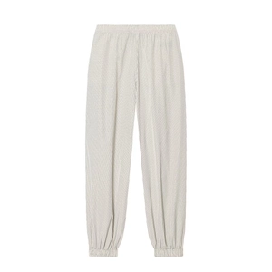 Detail of plaid nylon joggers featuring elastic pleated waist and tapered ankle cuffs