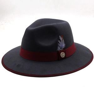 Detail of dark grey wool fedora with burgundy ribbon, feather accent and metal badge