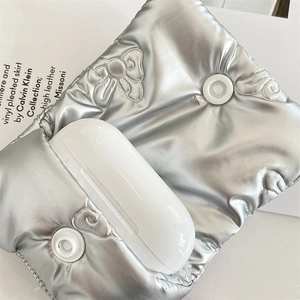 Detail of silver quilted earphone case featuring a bow pattern and snap closure