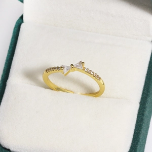 Nahaufnahme eines goldenen Schleifenrings mit Zirkonia-Besatz in einer Schmuckschatulle