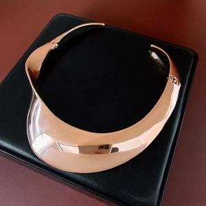 Detailed close-up of rose gold chunky torque necklace with a polished mirror finish
