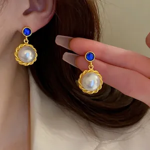Vintage gold pearl drop earrings with blue sapphire stud in classic French palace style
