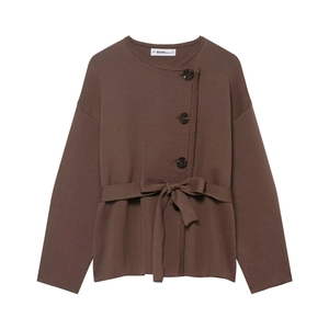 Close-up of brown knit cardigan featuring round neck and side button closure with belt