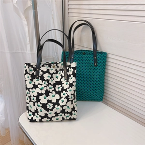 Detail of vintage canvas tote bags featuring floral and geometric patterns with leather straps