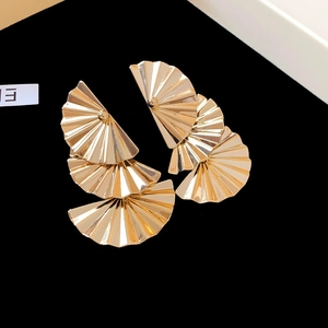 Detailansicht dreistufiger goldener Fächerohrringe mit strahlender Faltentextur