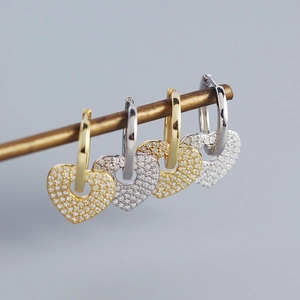 Detailed macro shot of S925 silver heart hoop earrings with cubic zirconia stones