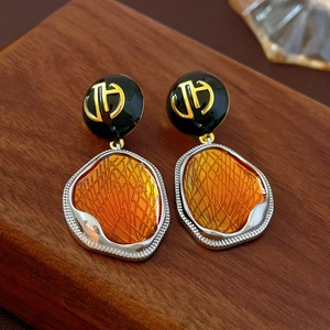 Vue détaillée des boucles d'oreilles vintage en résine orange sur support en bois
