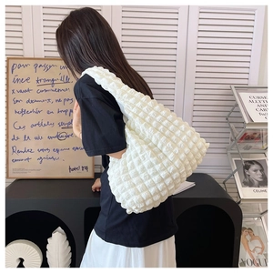 Detail of white pleated cloud bag showing soft bubbly texture and spacious interior
