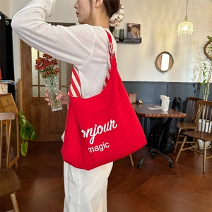 Détail du sac cabas rouge avec texte bonjour magic et bandoulière rayée
