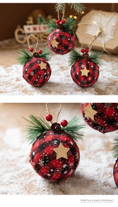 Close-up of red plaid Christmas ball ornament with pine needles, cones and wooden star