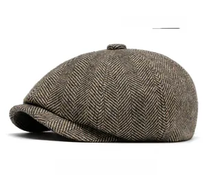 Close-up of vintage herringbone tweed fabric with green flecks on the newsboy cap