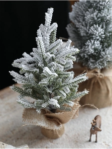 Close-up of mini flocked Christmas tree with snow detail and burlap base decor