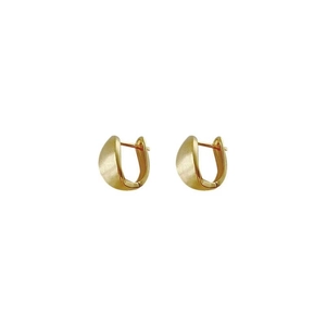 Macro detail of gold hoop earrings featuring a brushed matte exterior and polished inner surface