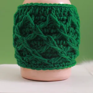 Detailed view of handmade emerald green crochet mug sleeve with textured knit pattern