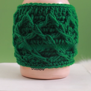 Detailed view of handmade emerald green crochet mug sleeve with textured knit pattern