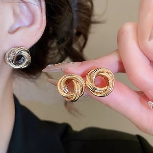 Détail de créoles rondes torsadées avec finitions polies en or et argent brillant